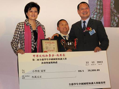 从左至右:外交部驻港特派员公署副特派员姜瑜女士(左一)和新华集团主席蔡冠深先生(右一)为小学组冠军颁奖。