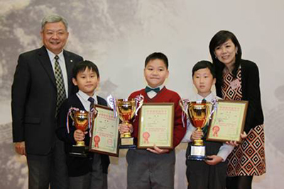 庄漪小姐(右)和招商局代表陈毅力先生(左)为个人赛小学组冠、亚、季军颁奖。季军圣公会仁立小学苏熙竣(左二),亚军英华小学的郑志恒(左三),冠军粉岭官立小学的曾思敏(左四)。