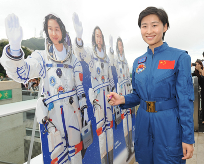 中国首名女航天员刘洋成为市民关注的焦点。她在参观山顶时,为自己的纸板公仔签名。